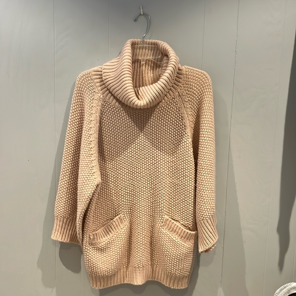 Knit Oversized cowl neck sweater. Front pockets. Ribbed cuffs and hem.